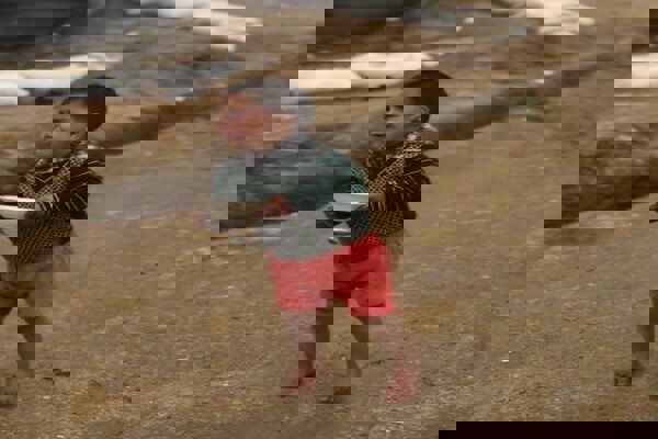 صحنه دردناک در غزه؛ کودکی زیر باران با ظرف خالی و چشمان گریان+فیلم